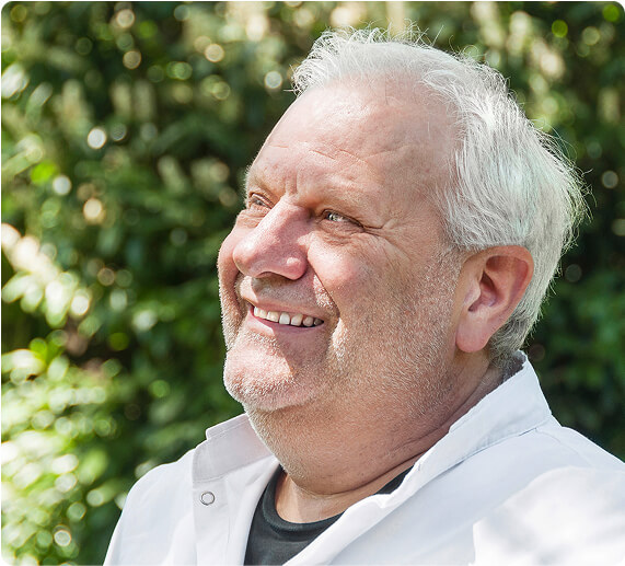 Mann schaut nach vorne links und lächelt.