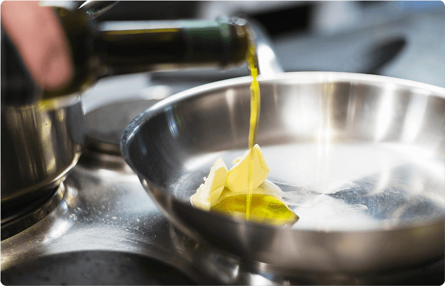 Butter und Olivenöl wird in eine Pfanne gegeben.